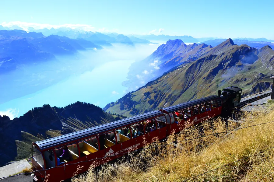 Ein Zug der Brienz Rothorn Bahn kurz vor der Bergstation, tief unten der Brienzersee