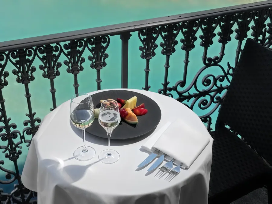 Ein gedeckter Tisch auf dem Balkon über der türkisgrünen Aare