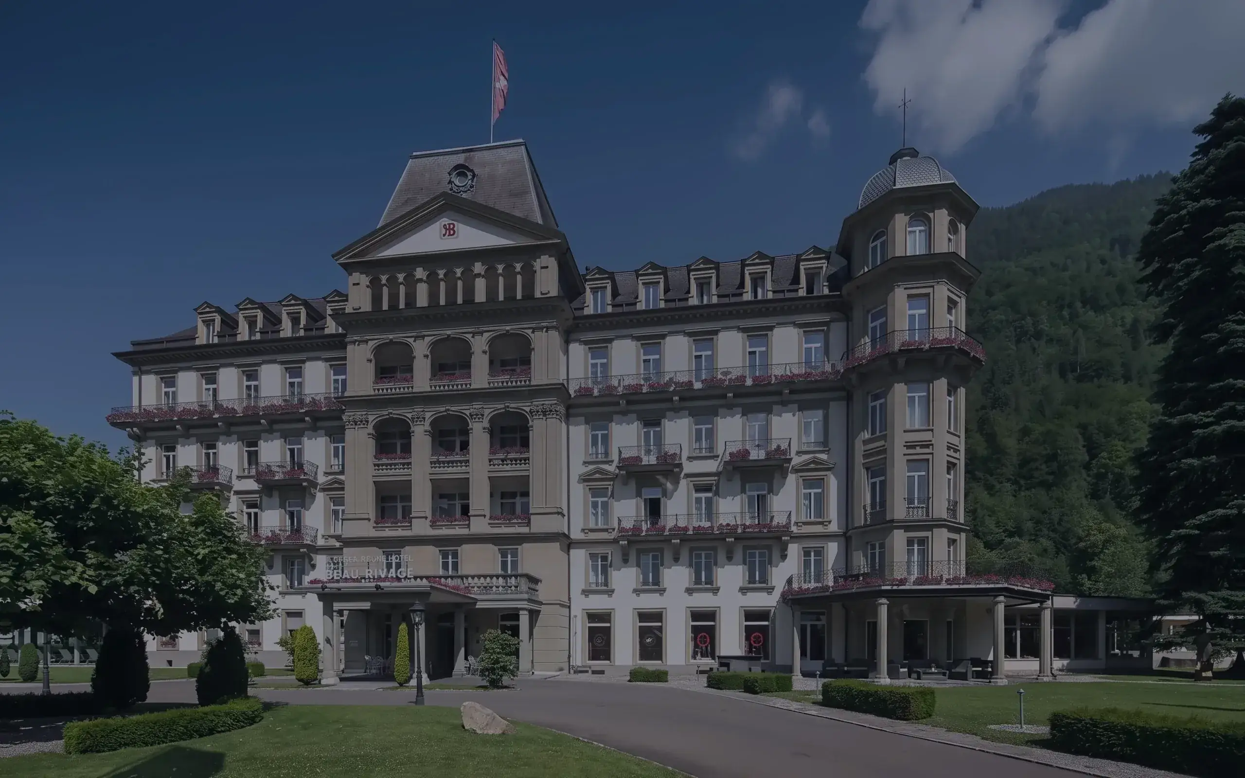 Das Grand Beau-Rivage im Sommer, dahinter die Berge