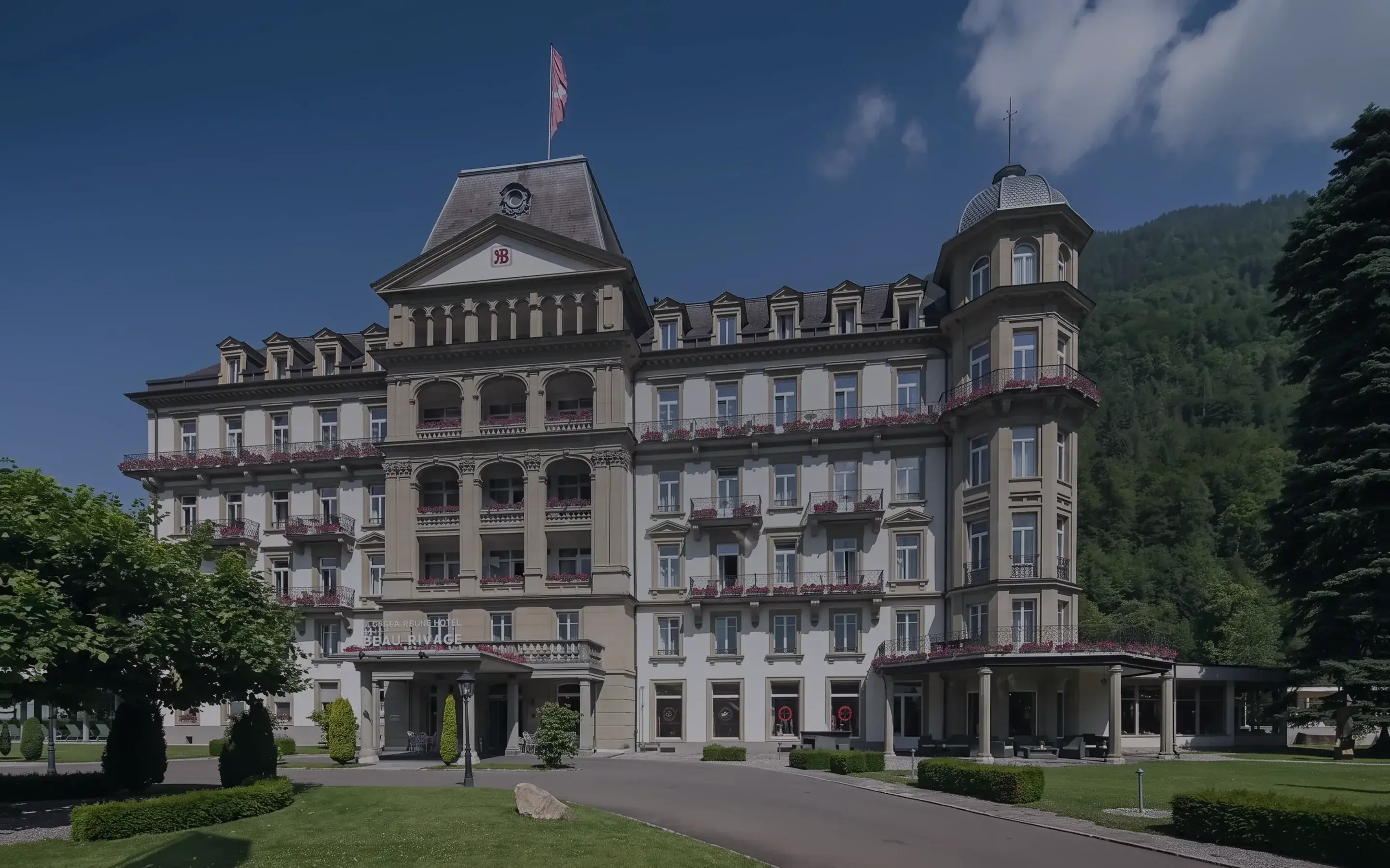 Das Grand Beau-Rivage im Sommer, dahinter die Berge