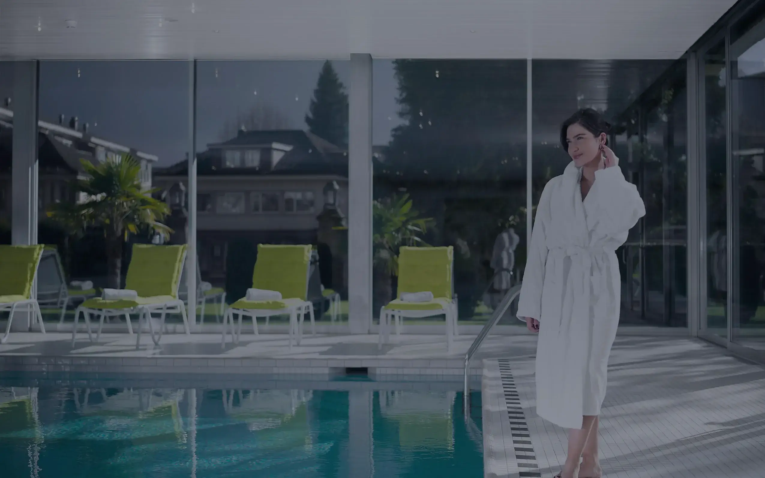 Ein Gast im Bademantel am Schwimmbad des La Vallée SPA