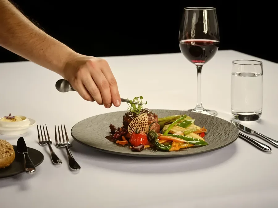 Ein Hauptgang wird serviert, dazu ein Glas Rotwein