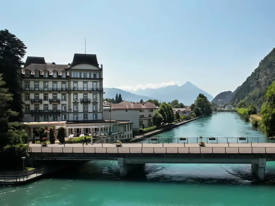Das Grand Beau-Rivage an der Aare mit der Brücke, dahinter die Berge