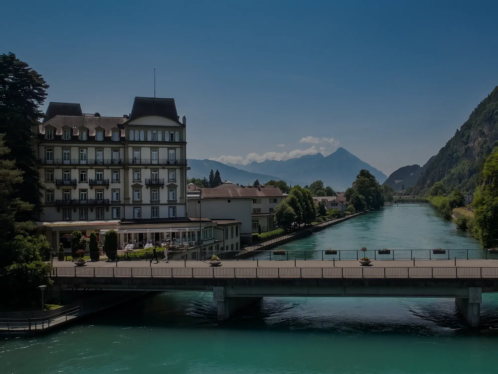 Das Grand Beau-Rivage an der Aare, dahinter die Berge