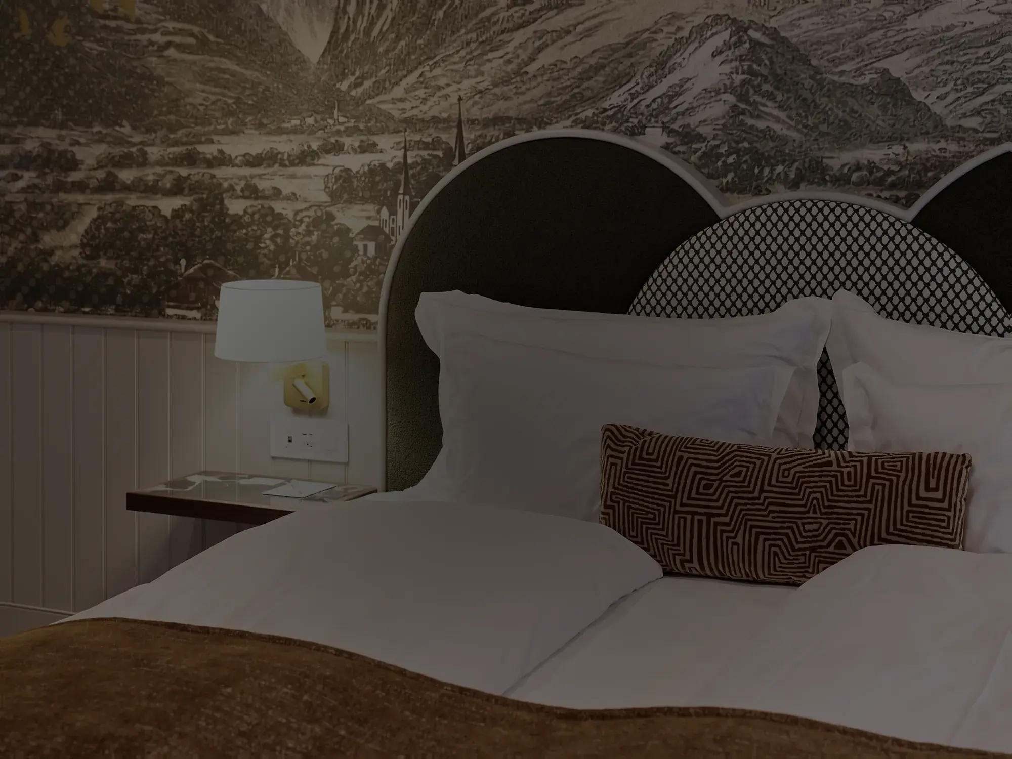 Bett mit Bergmotiv in einem neu renovierten Zimmer derselben Einrichtung