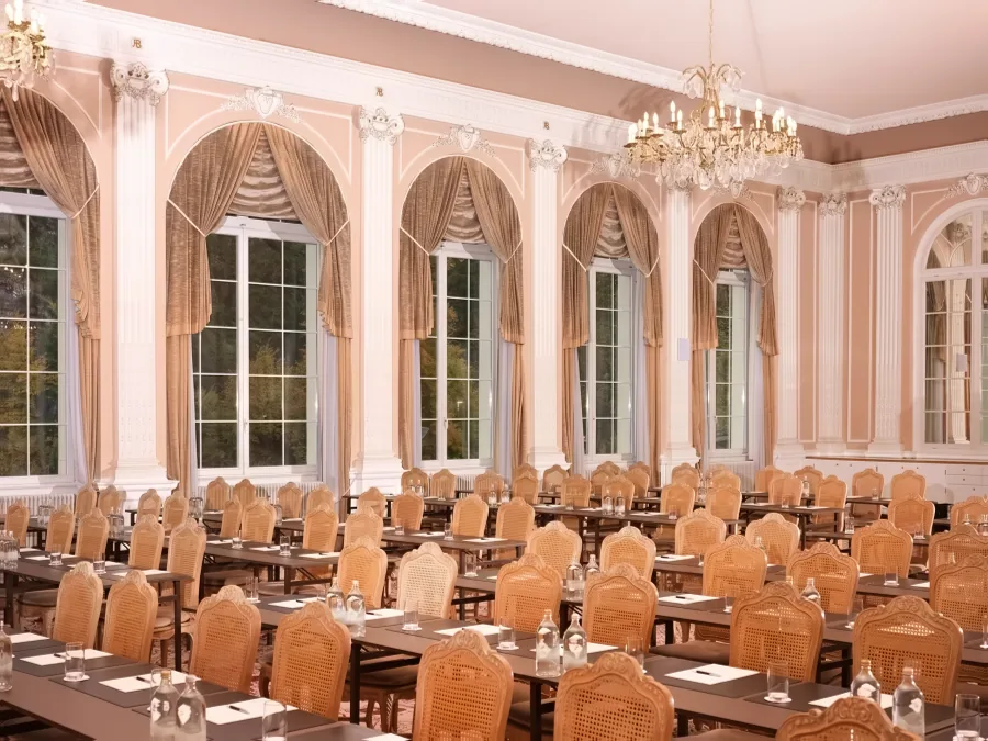 Der Ballsaal für eine Tagung bestuhlt, mit Leinwand und Kronleuchtern