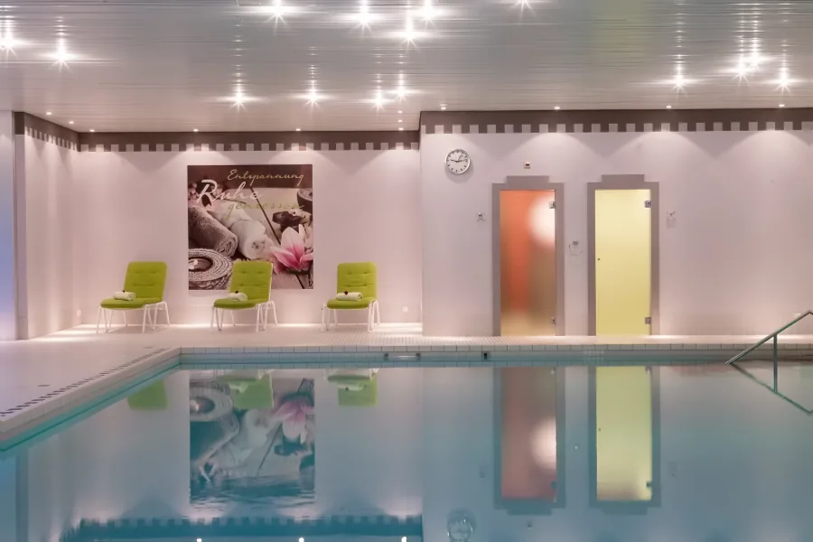 Das Schwimmbad mit den grünen Liegen