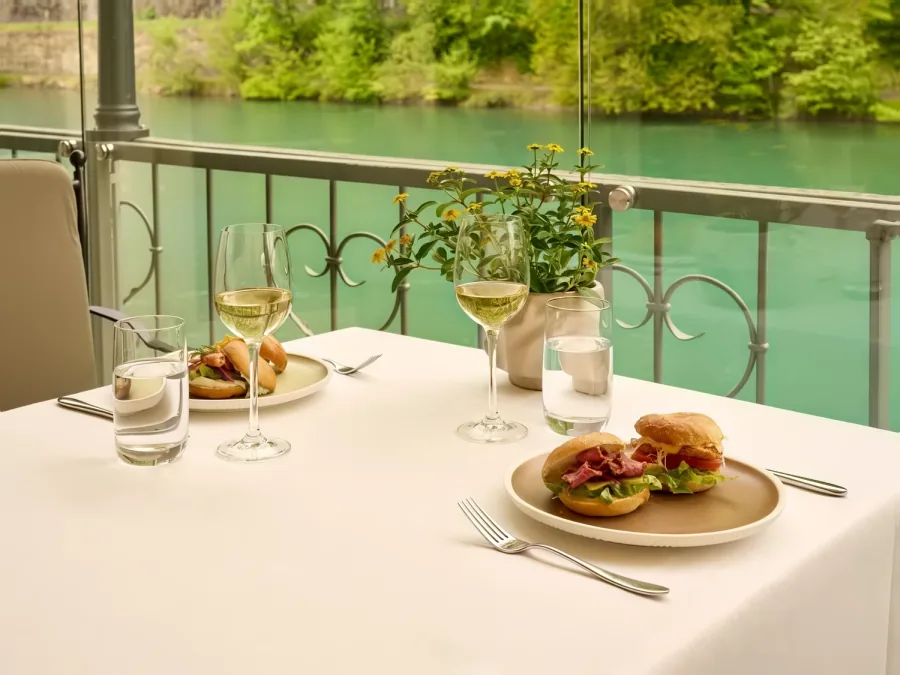 Bagels und Wein auf der Terrasse, dahinter die Aare