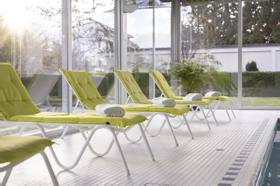 Die Liegen am Schwimmbad im Sonnenlicht