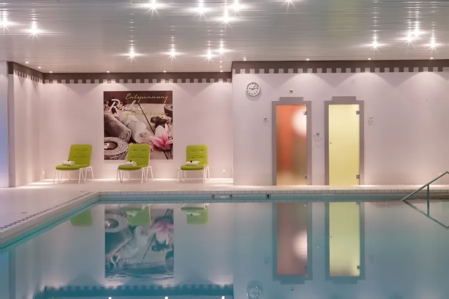 Das Schwimmbad am Abend, dahinter Sauna und Dampfbad