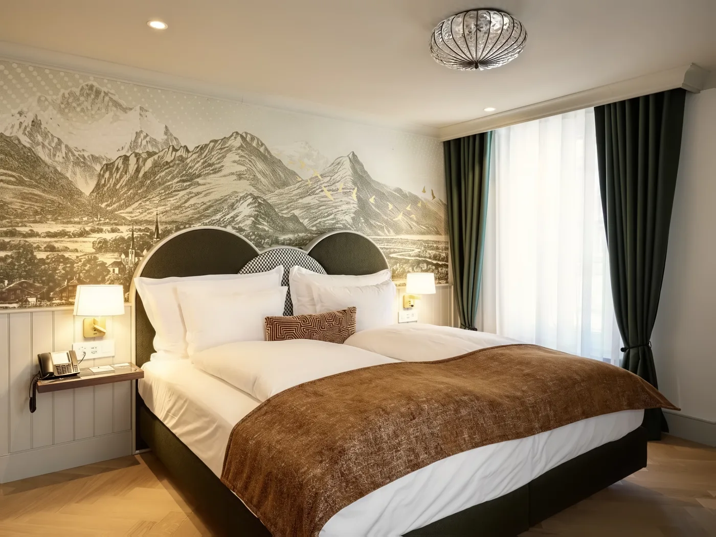 Bett mit Bergmotiv in einem neu renovierten Zimmer derselben Einrichtung